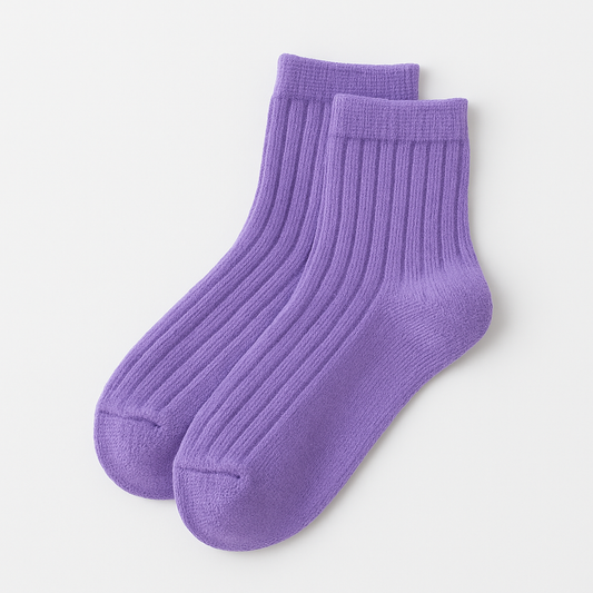 Pair of purple ribbed kids socks on a light gray background