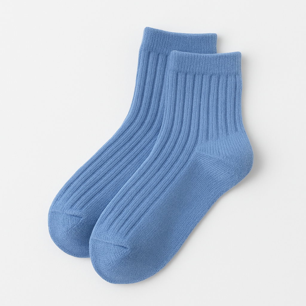 Pair of blue ribbed kids socks on a light gray background